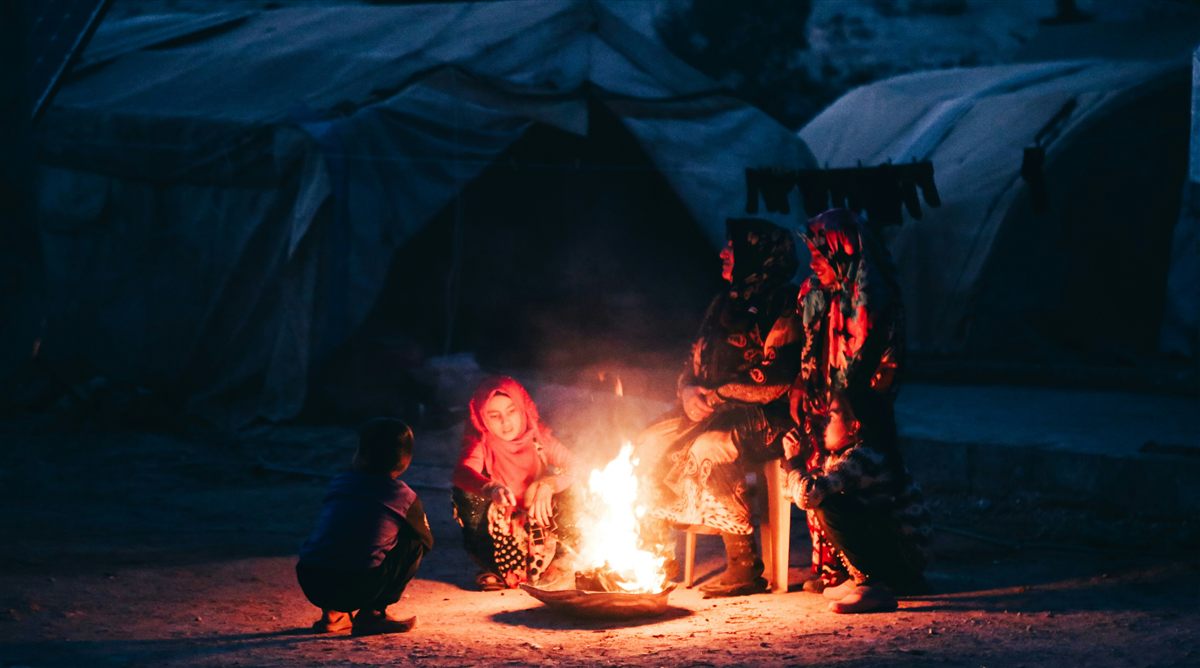 Start Here: Beginner's Guide to Emergency Preparedness - Building Your First Survival Plan Family gathered around a campfire representing calm and confident emergency preparedness